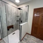 Cracked-cement-with-a-pony-wall-and-matte-black-trim-fold-down-seat-scaled-fb1ad572